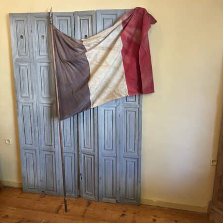 antieke Franse gemeentevlag met metalen schildje en houten stok